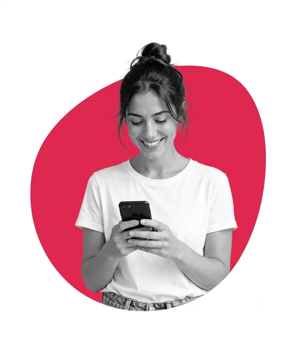 A woman smiling while looking at her phone